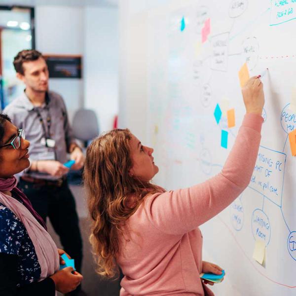 Members of the Academy of Primary Care working at a whiteboard