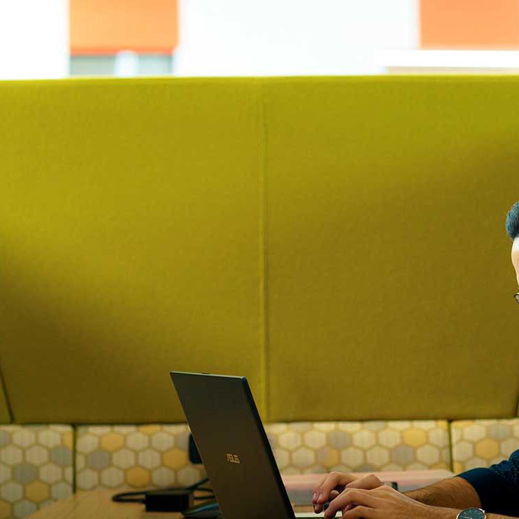 Medicine student Vassili Crispi working on a laptop on the collaboration deck in the Allam Medical Building at the University of Hull