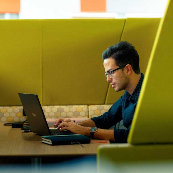 Student working on their laptop in the Allam Medical Building