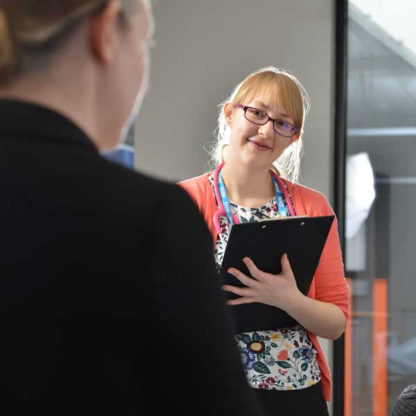 Medical student taking notes with a patient