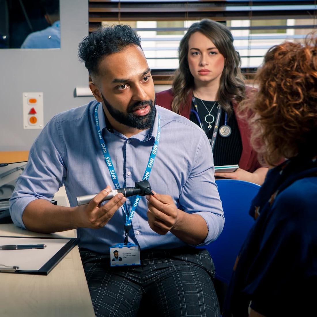 Medical student with patient a GP surgery, being supervised by a GP