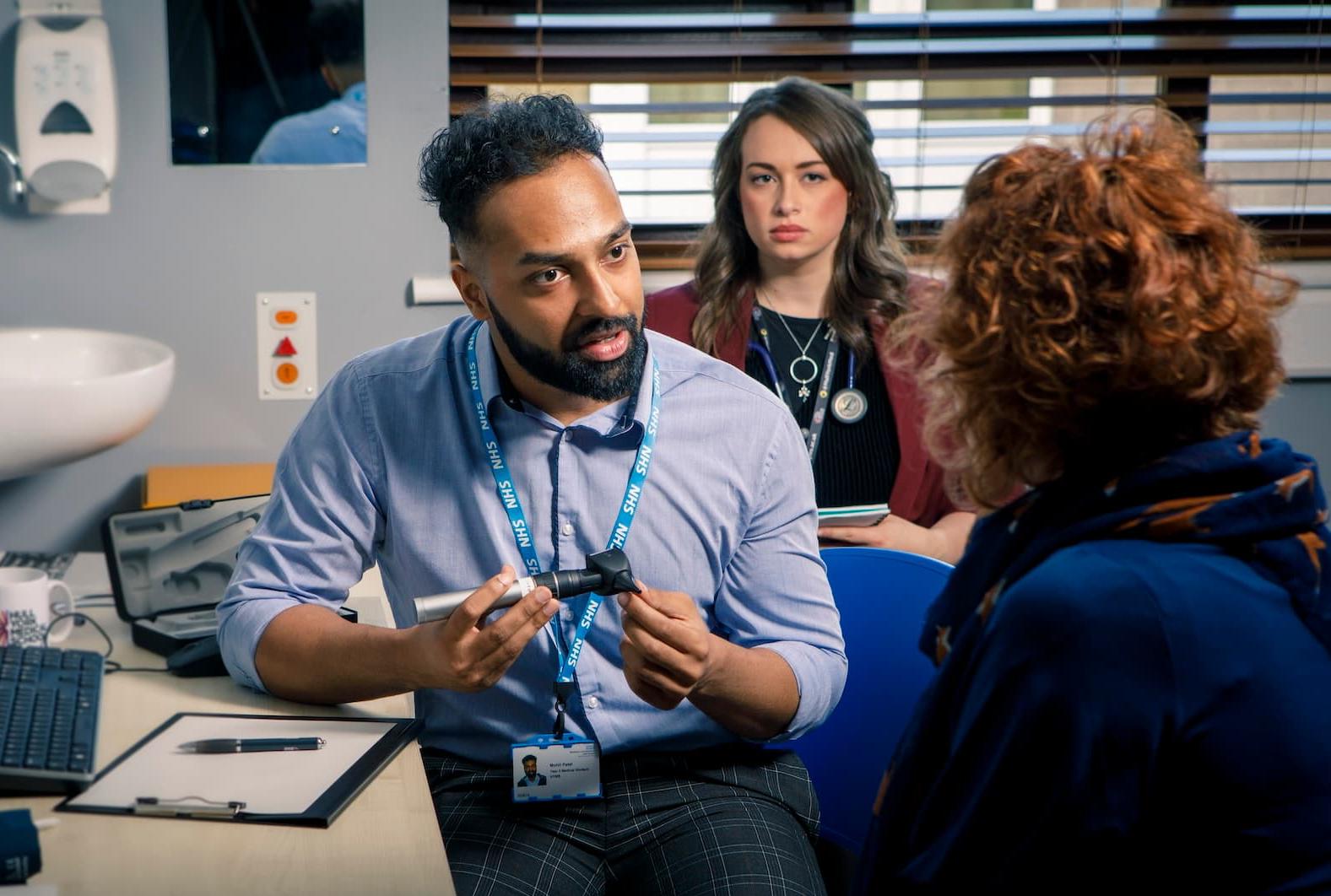 Medical student with patient a GP surgery, being supervised by a GP