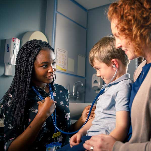 Student with a child and parent in a GP surgery