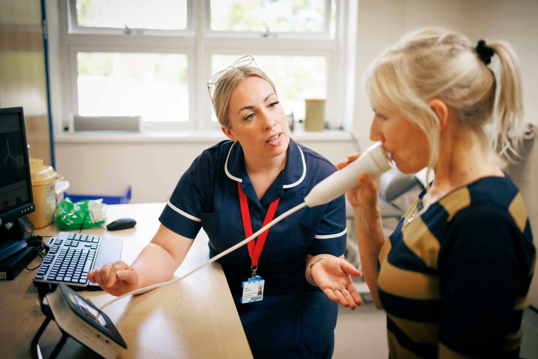 Asthma research nurse with a patient doing breathing tests