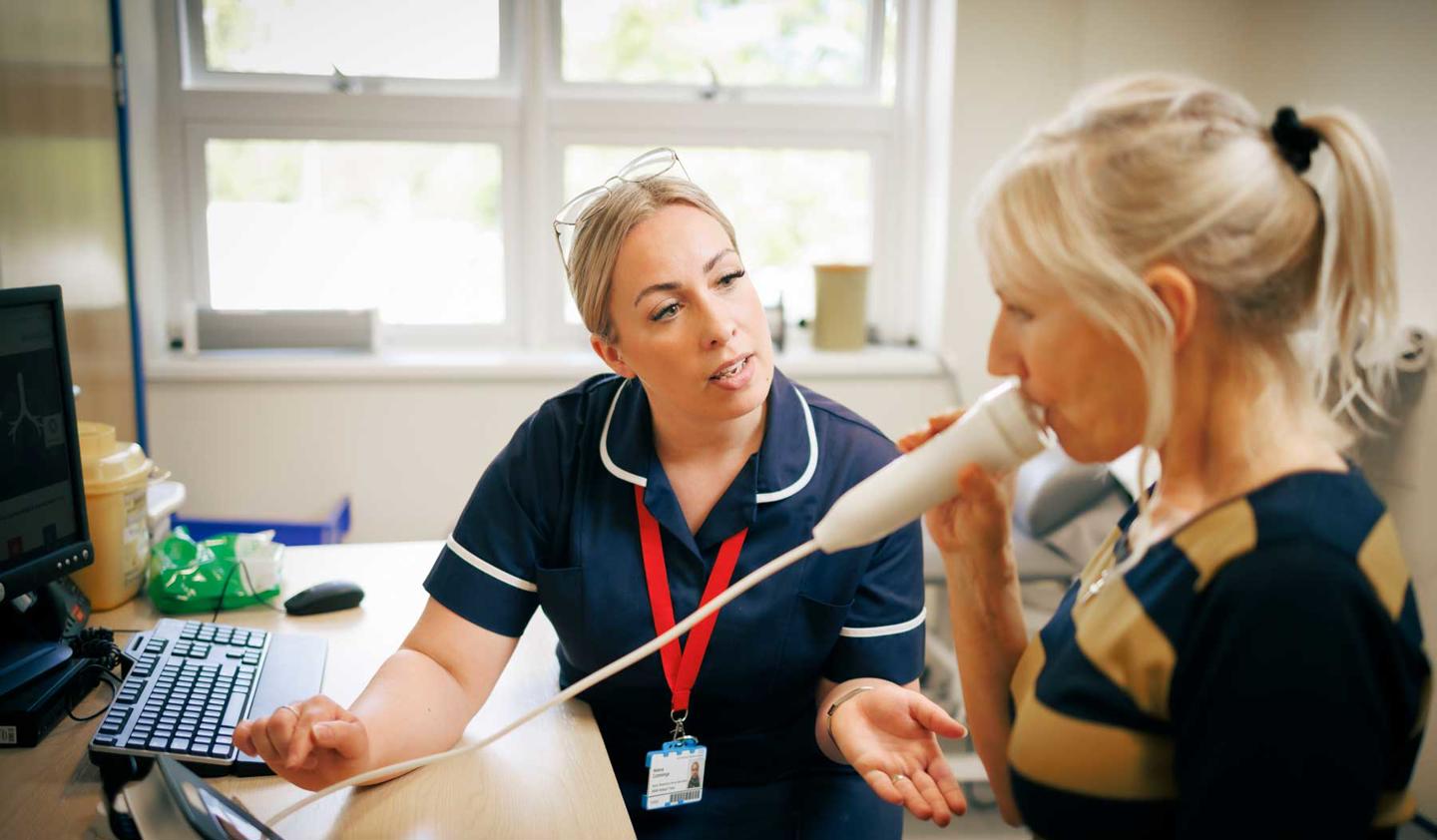 Asthma research nurse with a patient doing breathing tests