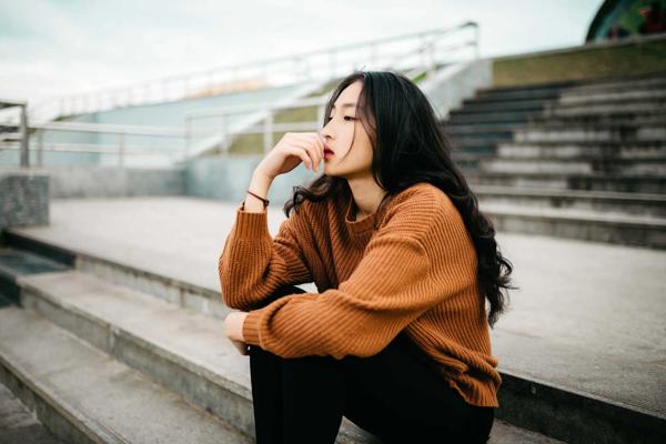 Women sat on steps looking deep in thought